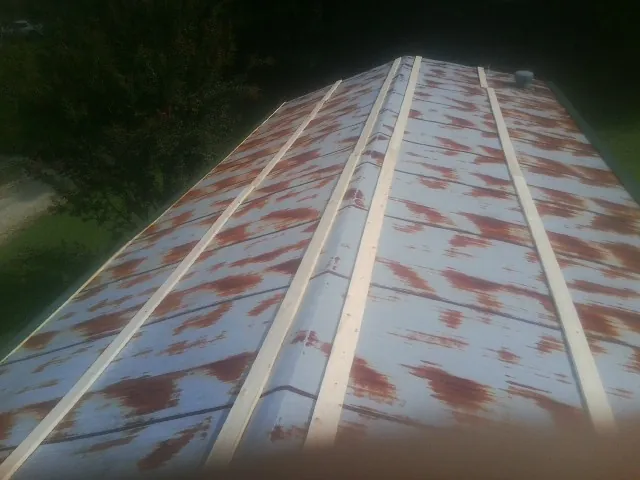 Rusted metal roof panels with new wood purlins before replacement — Storm Damage Roof Repair in Diberville by Roofing Brothers