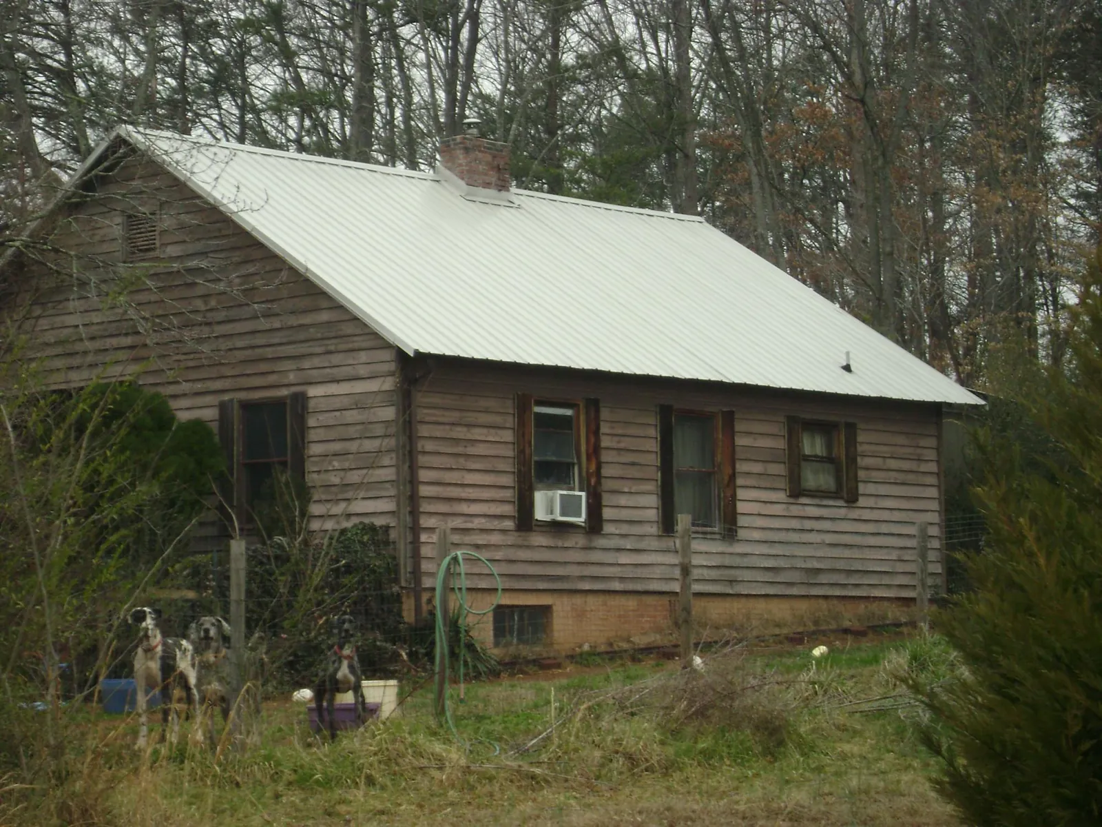 White metal roof on an old wood sided farmhouse, from a Metal Roof Installation job in Diberville
